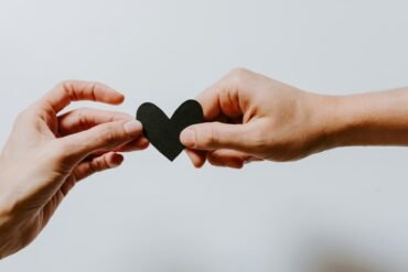 two person holding papercut heart