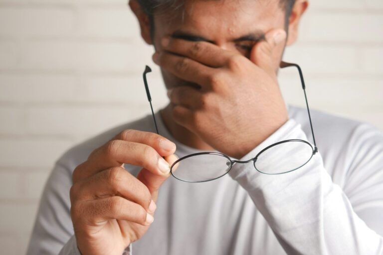 a man holding a pair of glasses up to his face