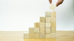 A person placing a piece of wood into a pyramid